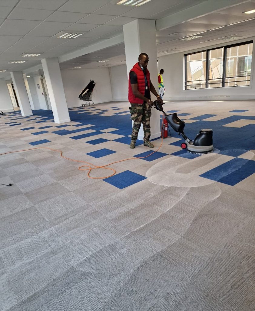 Nettoyage de la moquette avec une brosse et des vitres dans un immeuble