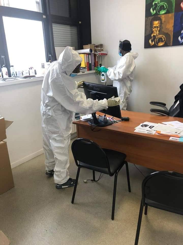 deux agents qui nettoient et désinfectent un bureau